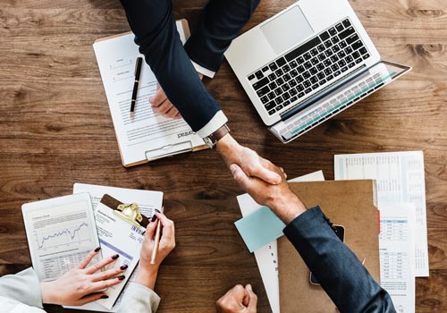 Two people shaking hands after successfully outplacing an exiting employee.